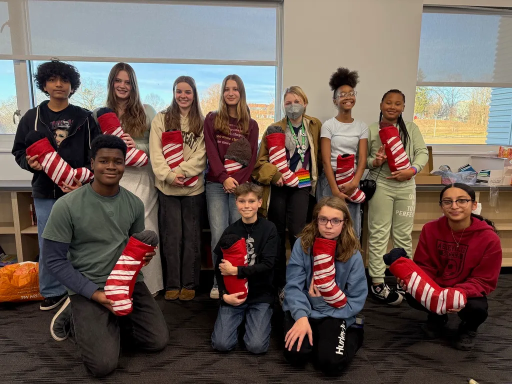 Students from the IRL afterschool program holding red and white striped stockings